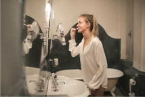 Girl in white shirt brushing teeth